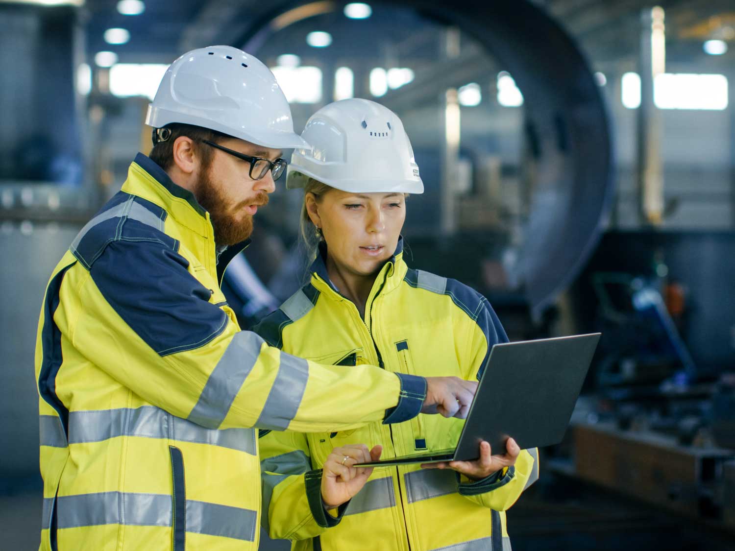 man and woman looking at a laptop in their jobs